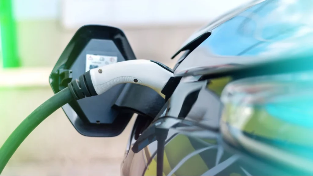 Electric vehicle charging connector plugged into car showing standard EV charging before using a generator