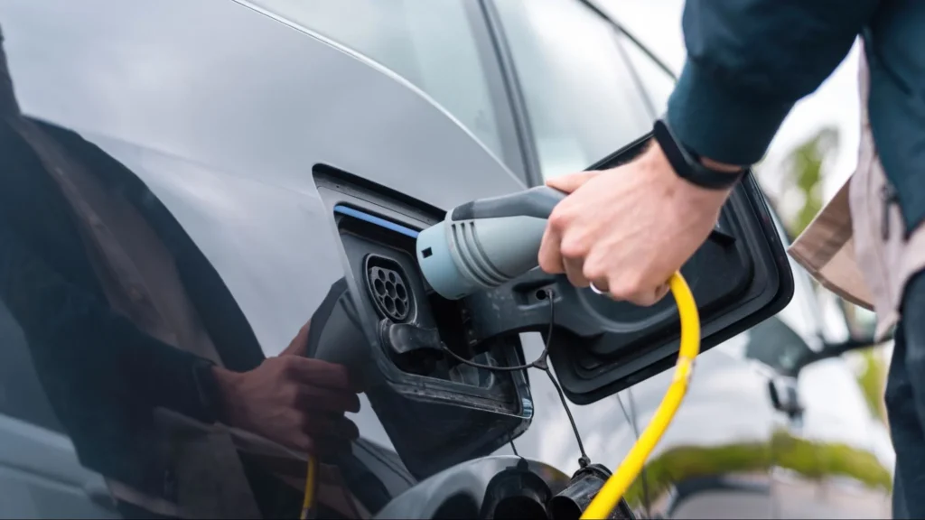 Close-up of EV charging plug connected to electric car showing charging port used for generator-based EV charging setup