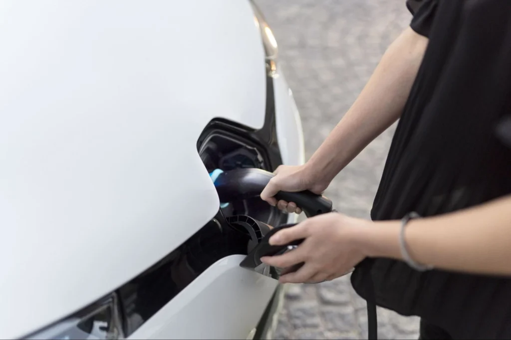 Close-up of electric vehicle being plugged in for home charging using Level 2 charger