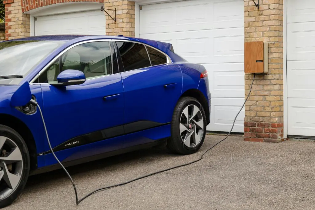 Electric car charging at home using a wall-mounted Level 2 EV charger in a safe residential setup