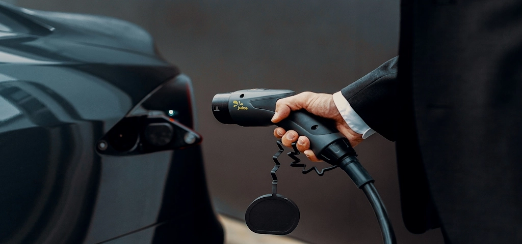 a man plugging in NEMA 5-15 Plug into EV