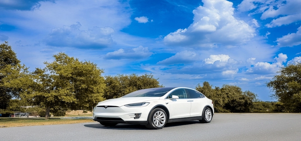 a Tesla EV driving in a neighborhood