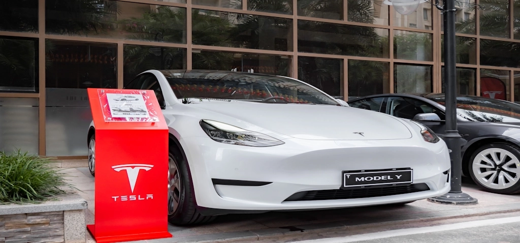 a Tesla EV parked at a charging station